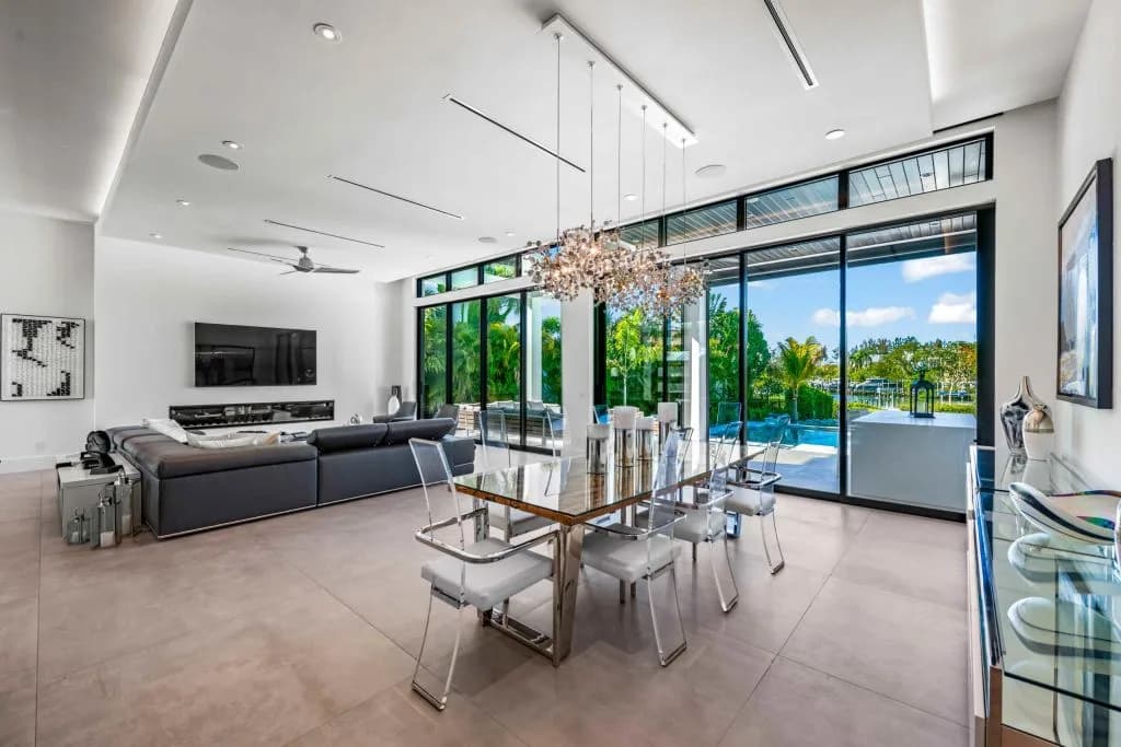 Light-filled dining room with glass walls opening to the pool in a Nutter custom home