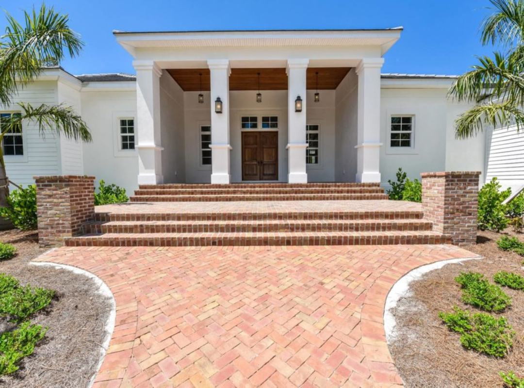 Newly completed luxury custom home with brick paver entry staircase and covered front porch built by Nutter Custom Construction in Sarasota FL