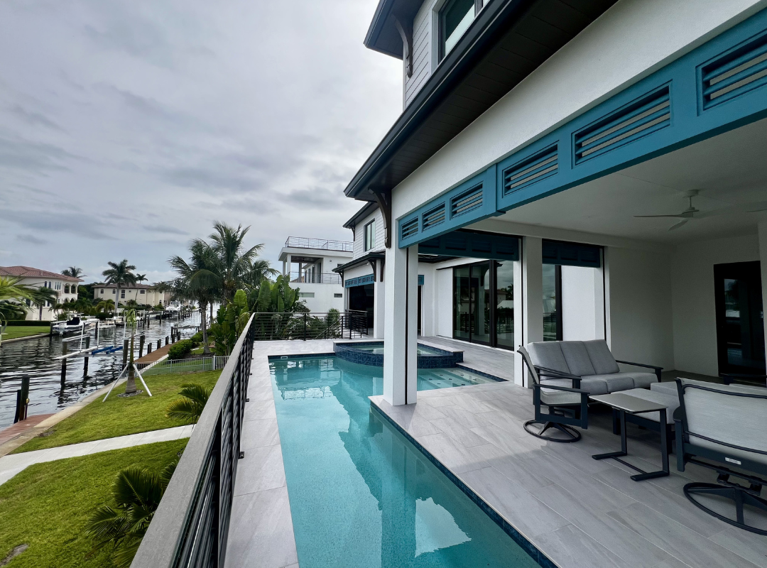 Luxury custom home pool with cascading water feature staircase and outdoor living area in Sarasota FL built by Nutter Custom Construction