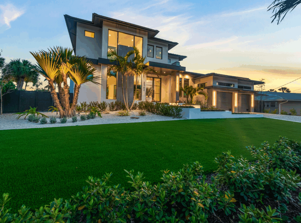 Nutter Custom Construction luxury custom home exterior at dusk in Sarasota, FL, with modern architecture, palm landscaping, and turf lawn