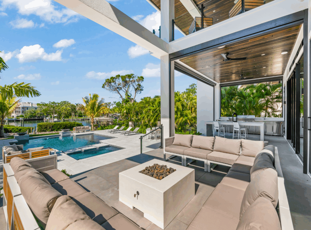 Nutter Custom Construction waterfront outdoor living space in Sarasota, FL, with covered lounge, pool, spa, and canal view